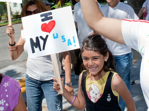 Child holding a "I heart My USA!" sign