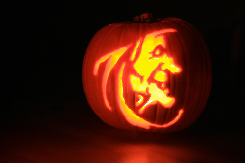 A witch carving on a pumpkin