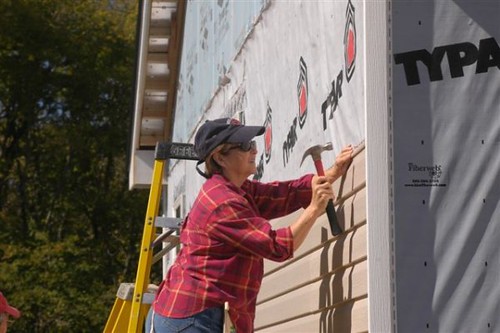 Habitat for Humanity volunteer using hammer to help with home building