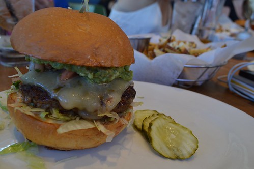 Handcrafted burger with cheese and pickles on the side