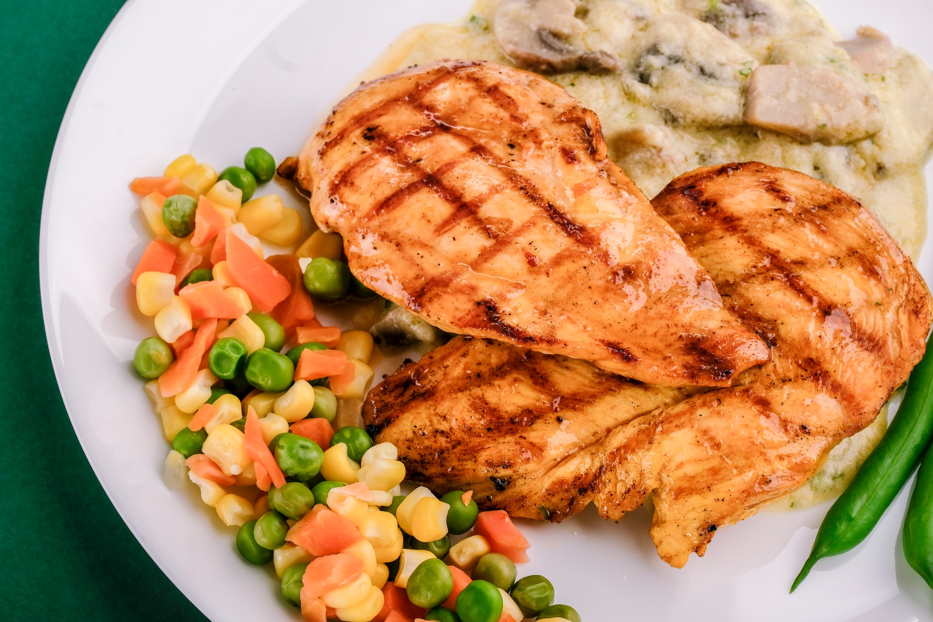 Overhead on plate of grilled chicked with steamed vegetables