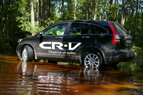 Black Honda CR-V with CR-V painted on left side in river in Europe