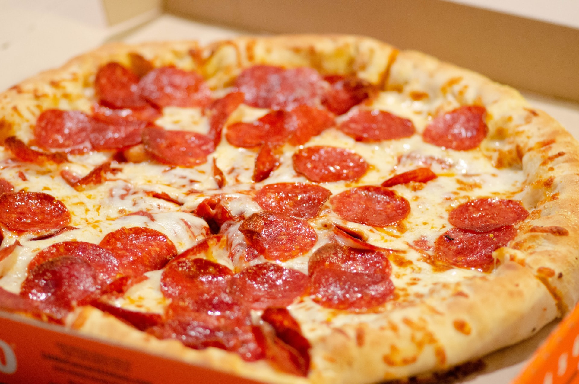 Pepperoni pizza cut into triangle slices in pizza box