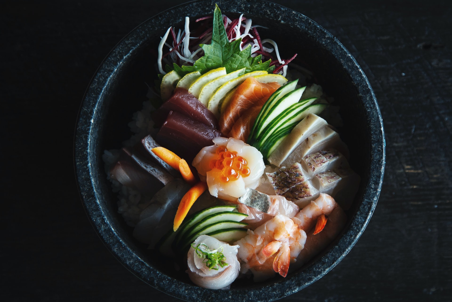 Overhead on bowl of Hawaiian food with fish and veggies