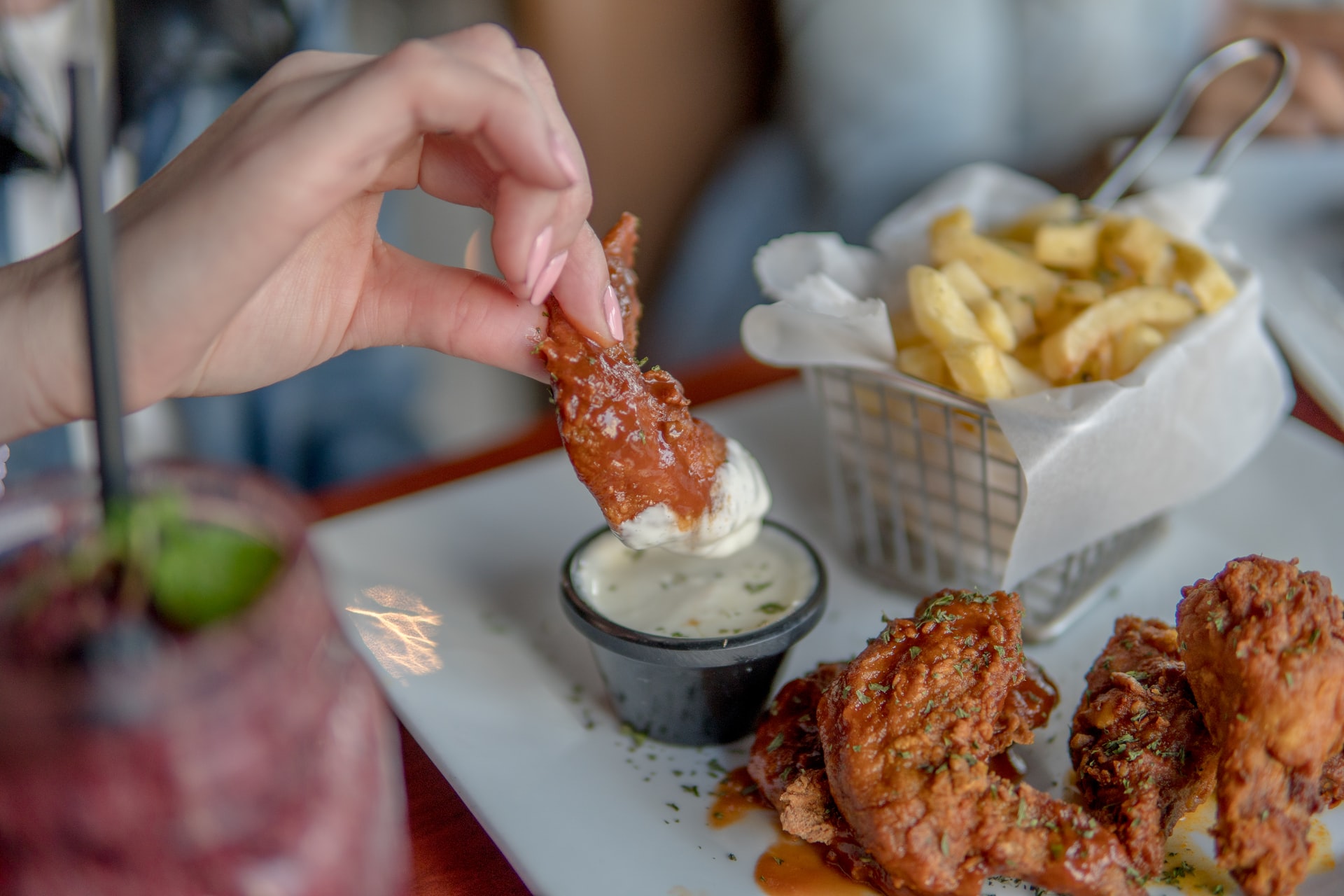 Dipping wings in ranch with side of fries
