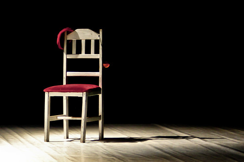 Chair with a red seat on a theatre stage in a spotlight