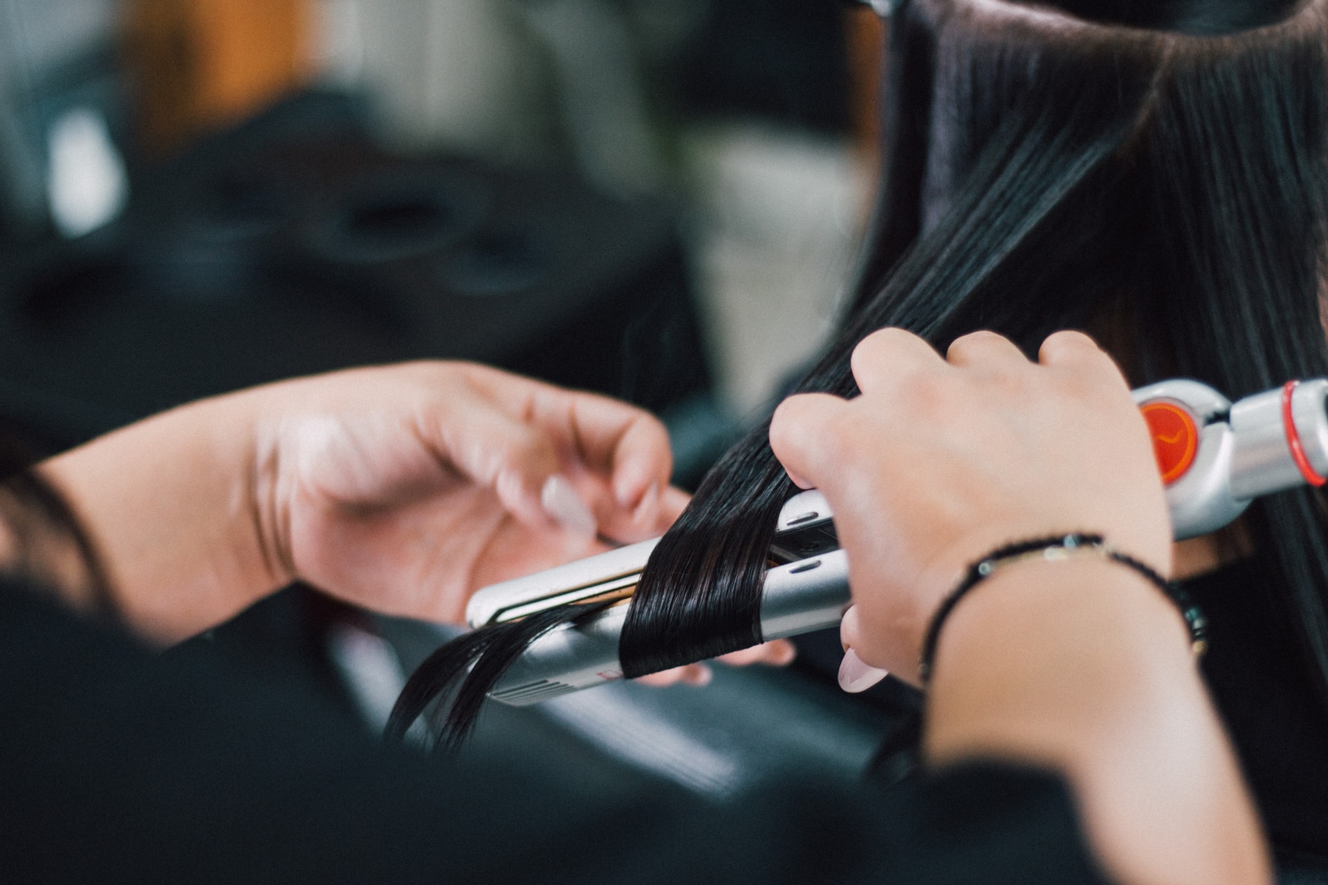 Salon employee curling woman's hair