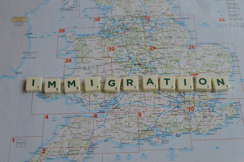 Immigration spelled out in scrable letters over a map