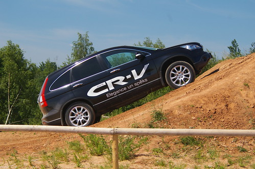 Honda CR-V with the logo on the side driving up a dirt hill